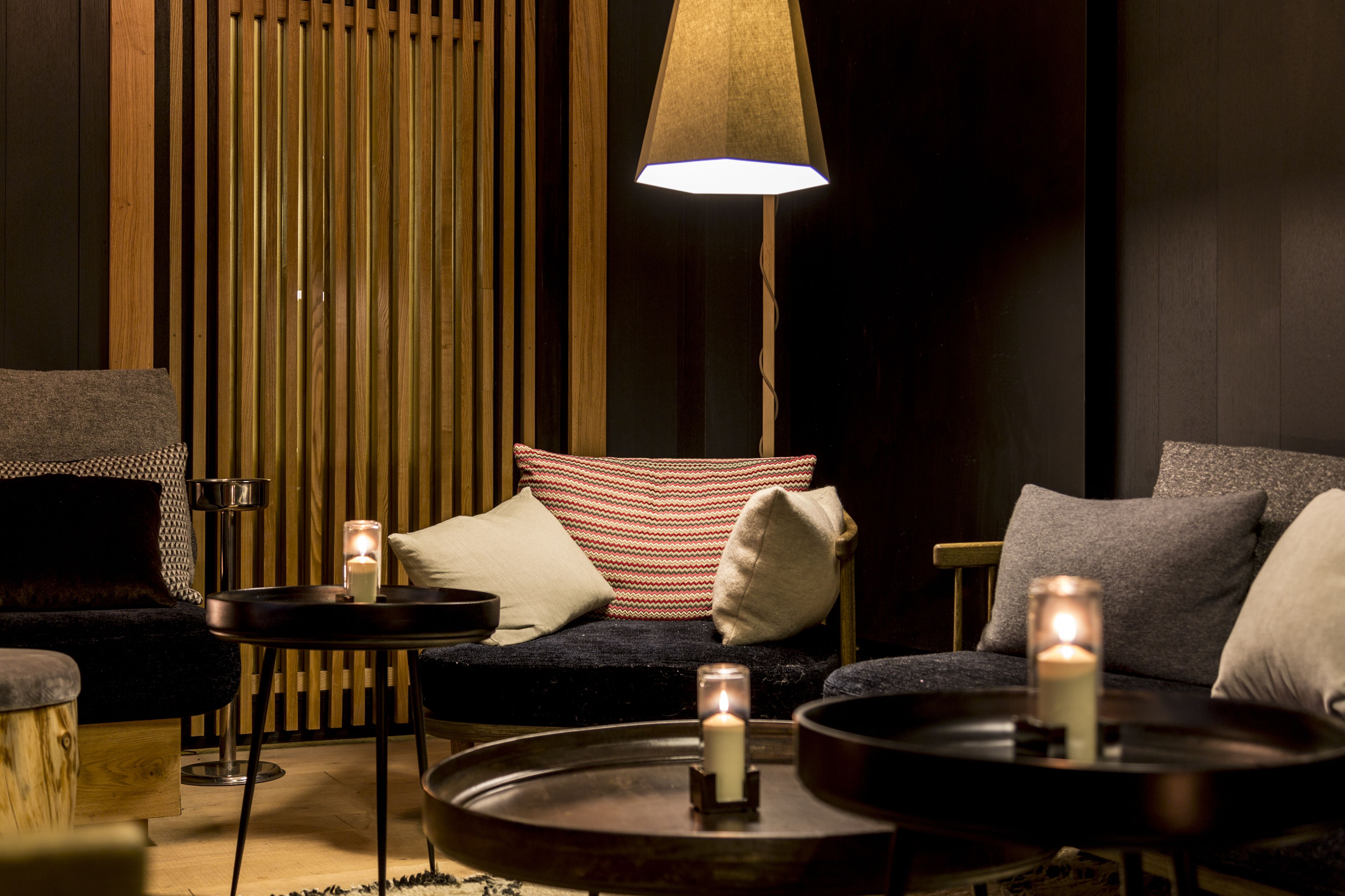 A cozy seating area with a sofa, two side tables, and a floor lamp.
