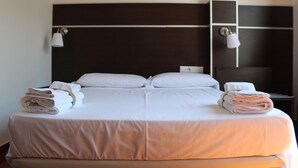 A double bed with white linens and two side tables with lamps. - Hotel Sagunto (Sagunto)