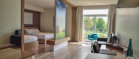 Una habitación de hotel moderna con cama, escritorio, ordenador portátil y vistas al exterior.