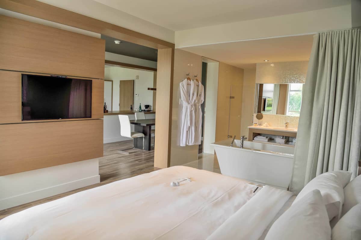 Suite ejecutiva, 1 cama King size y sofá cama, vista al campo de golf | Ropa de cama hipoalergénica, escritorio y cortinas blackout