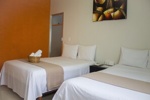 A hotel room with two beds, a basket of towels, and a painting on the wall.