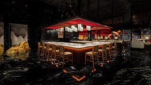 A modern restaurant with a central island, multiple seating areas, and a distinctive red ceiling. - Wynn Palace (Cotai)