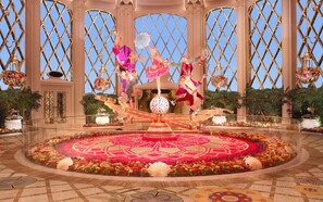 A grand atrium with a central floral arrangement, ornate columns, and a large decorative globe. - Wynn Palace (Cotai)