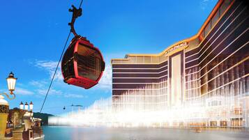 Experience the tranquility of Wynn Palace, situated beside a serene body of water, with a cable car system offering a unique transportation experience.