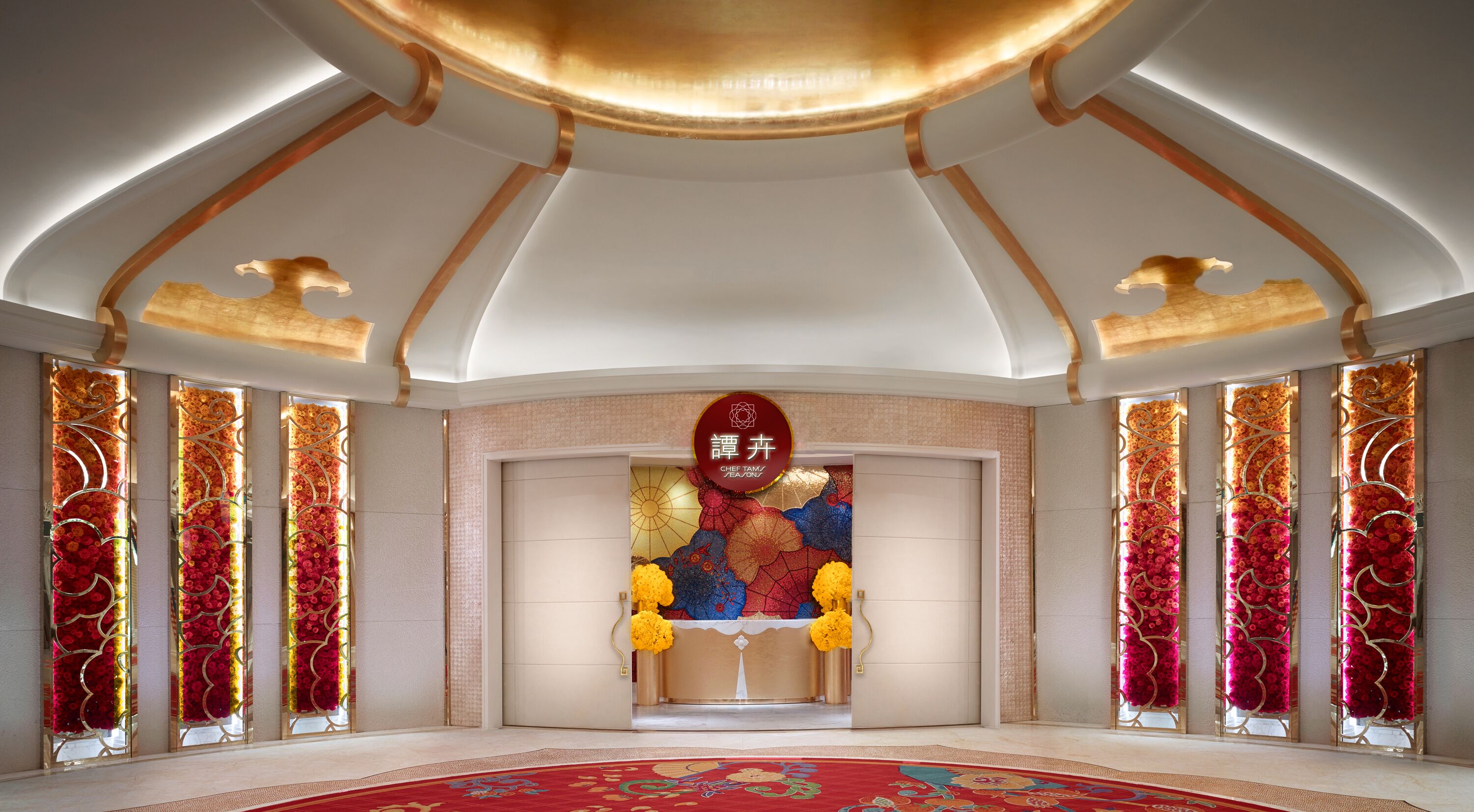 A spacious lobby with a central altar, decorative floral panels, and a patterned carpet.