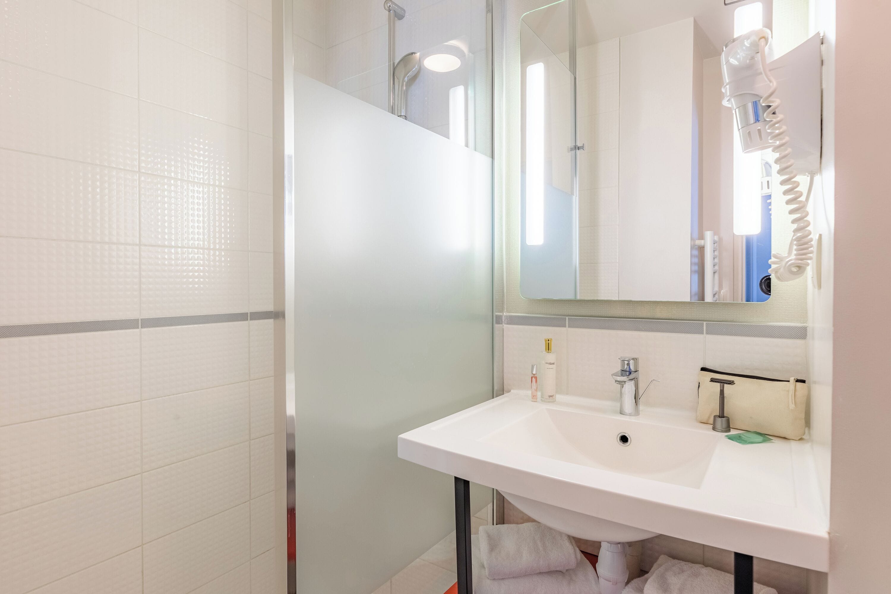 Ein modernes Badezimmer mit Waschbecken, Spiegel und Handtuchhalter.