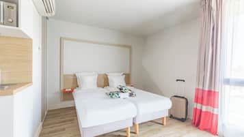 Ein modernes Hotelzimmer mit Bett, Schreibtisch und Koffer.