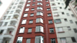 A multi-story building with a red facade and white windows. - Hotel PC (São Paulo)