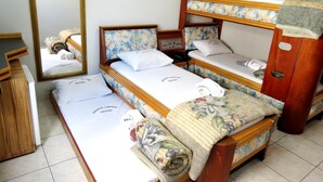 A hotel room with three bunk beds, a wooden dresser, and a mirror. - Hotel PC (São Paulo)