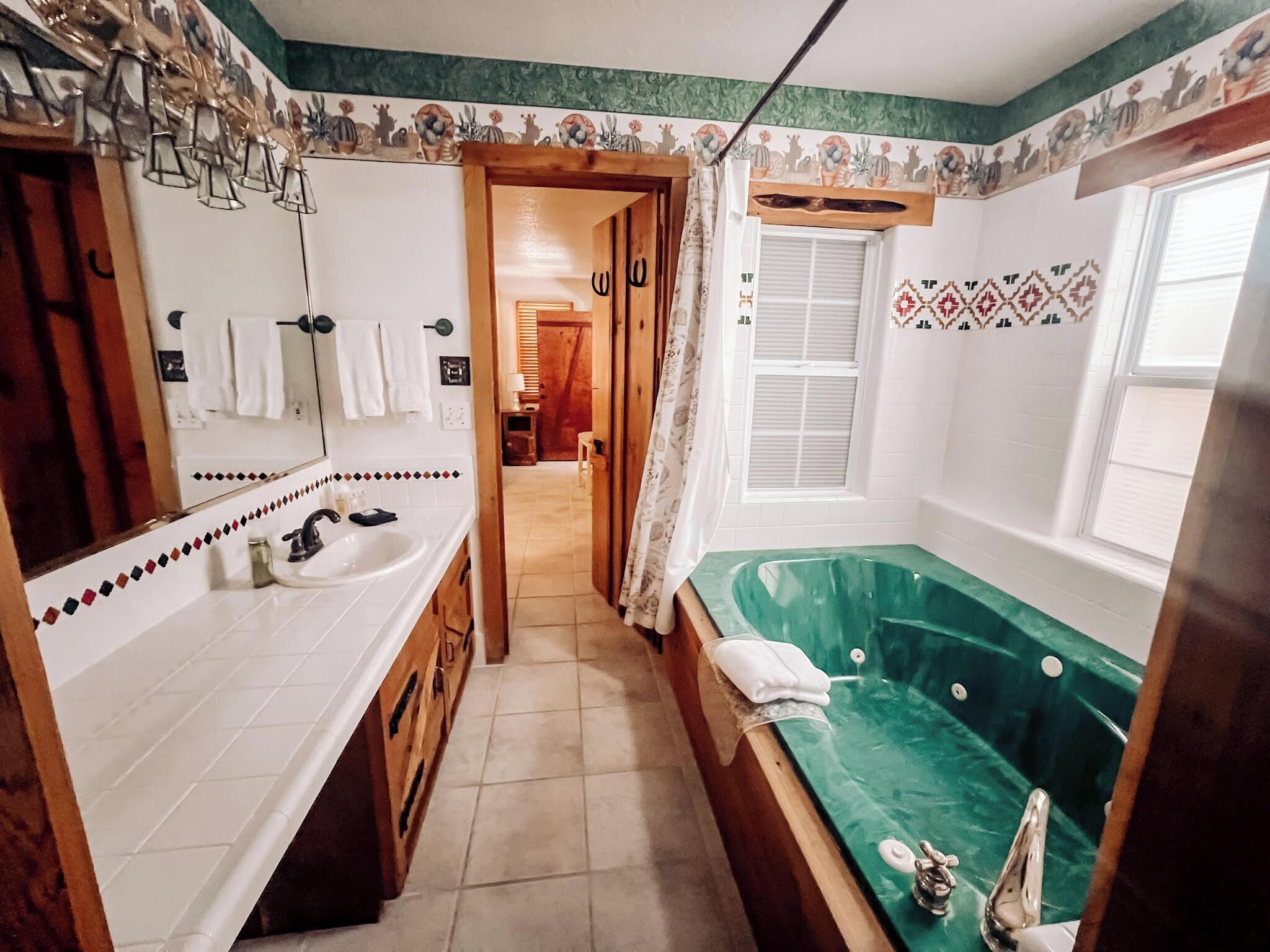 Ein Badezimmer mit großem Spiegel, Waschbecken, Badewanne und Dusche.