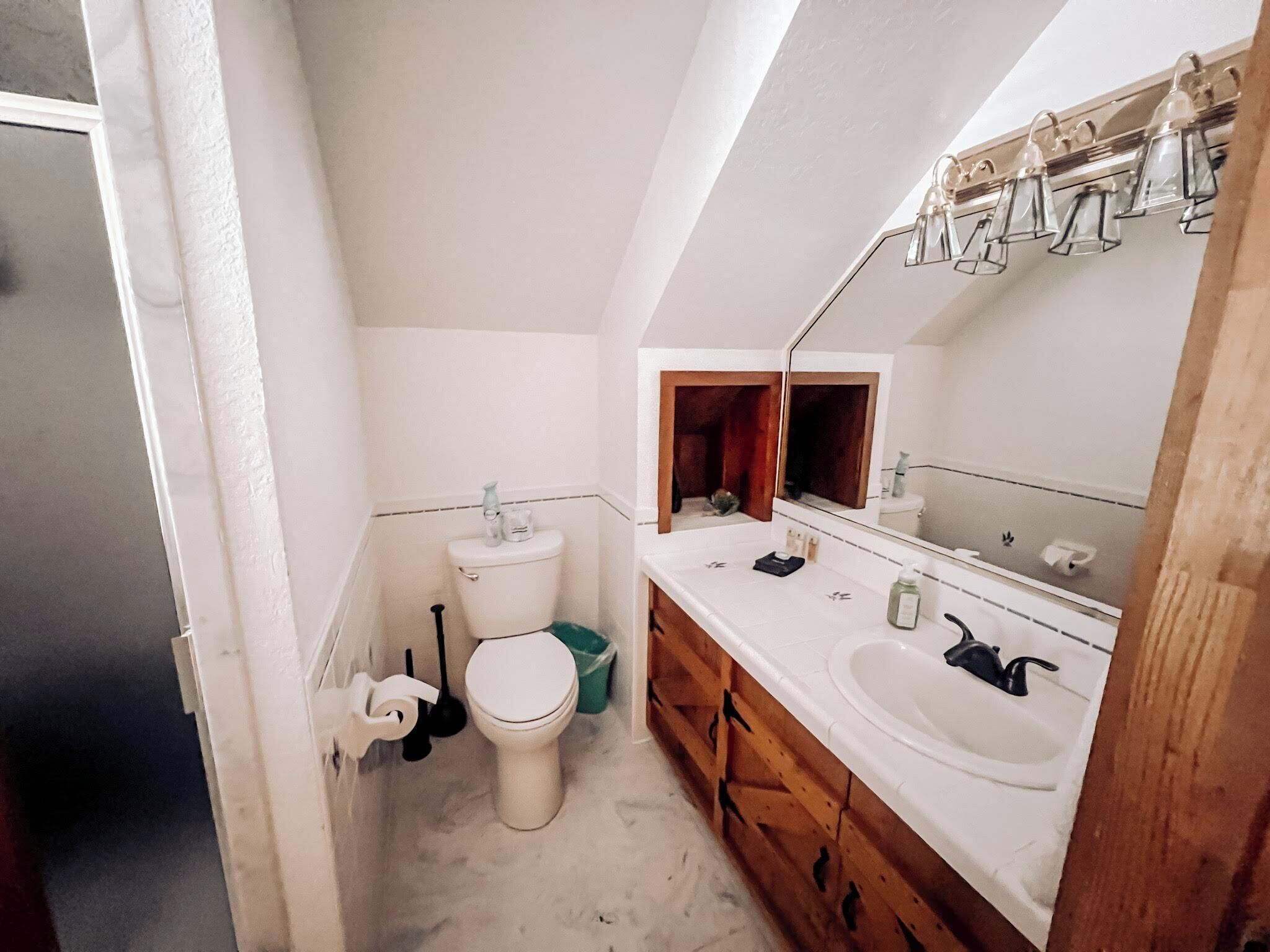 Un baño pequeño y funcional con inodoro, lavabo y espejo.