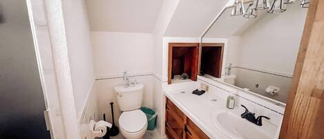 Un baño pequeño y funcional con inodoro, lavabo y espejo.