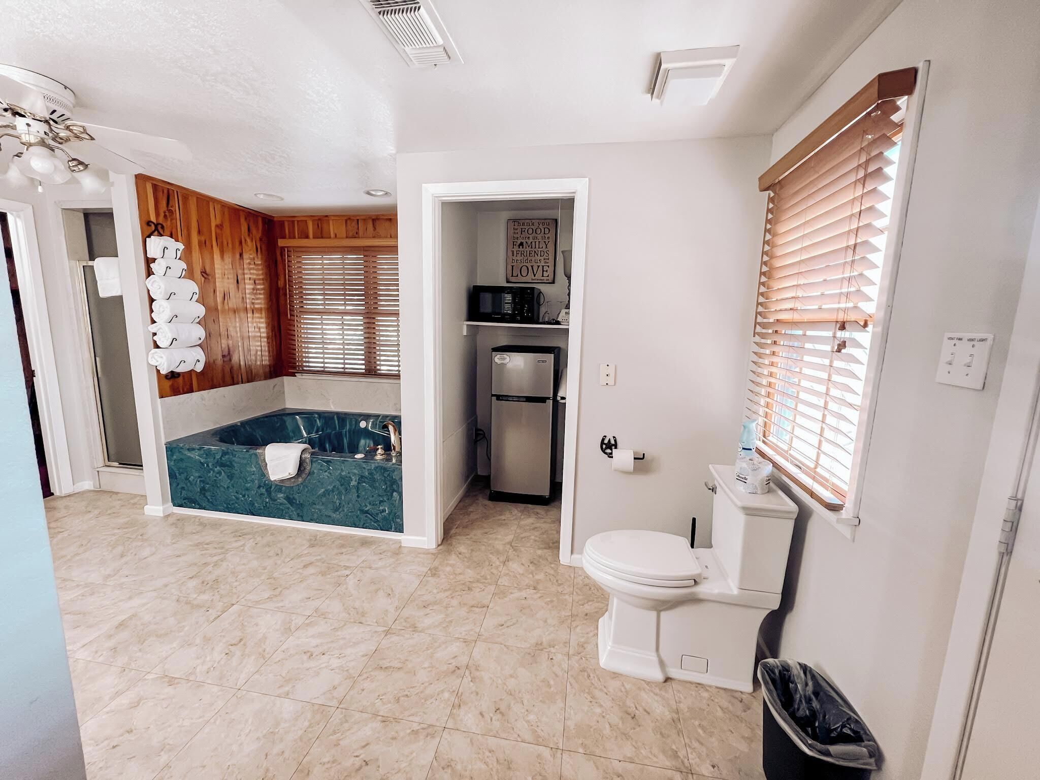 A bathroom with a bathtub, toilet, and a shower area.