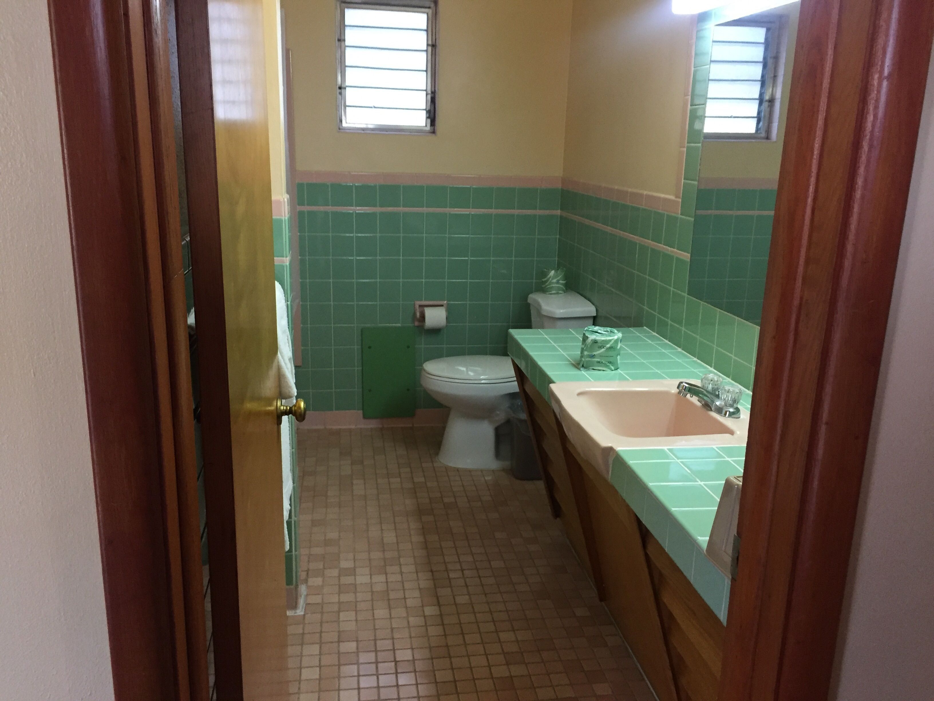 Ein Badezimmer mit Toilette, Waschbecken und Spiegel.