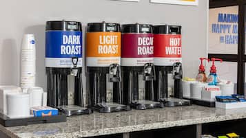 A coffee station with four dispensers labeled DARK ROAST, LIGHT ROAST, DECAF ROAST, and HOT WATER.