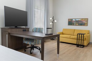 Ein modernes Wohnzimmer mit einem Holztisch, einem Fernseher, einer Couch und einem kleinen Tisch.