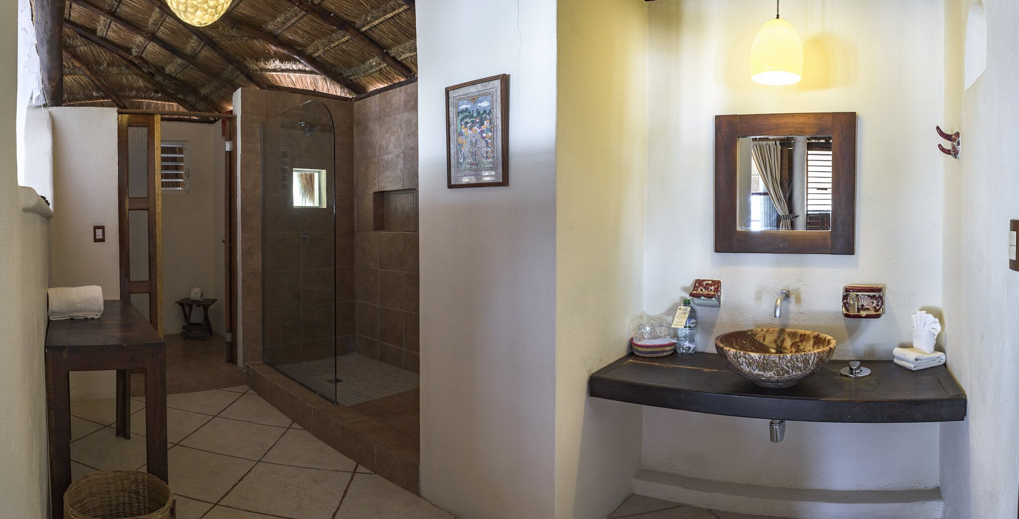 A bathroom with a glass-enclosed shower, a sink with a large bowl, and a mirror above the sink.