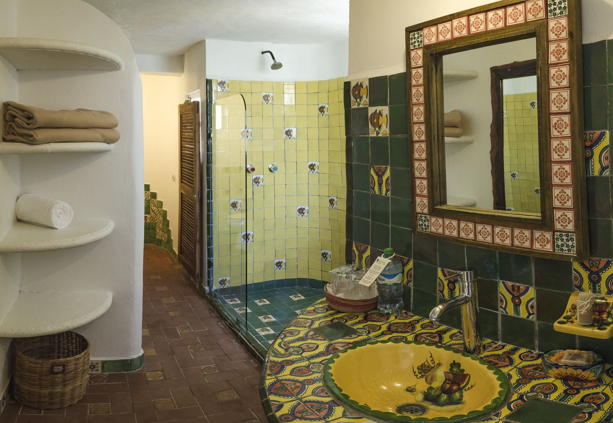 A bathroom with a yellow sink, a mirror, and a shower with a glass door.