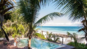 A wooden deck with a pool overlooking a beach. - Nueva Vida de Ramiro (Tulum)