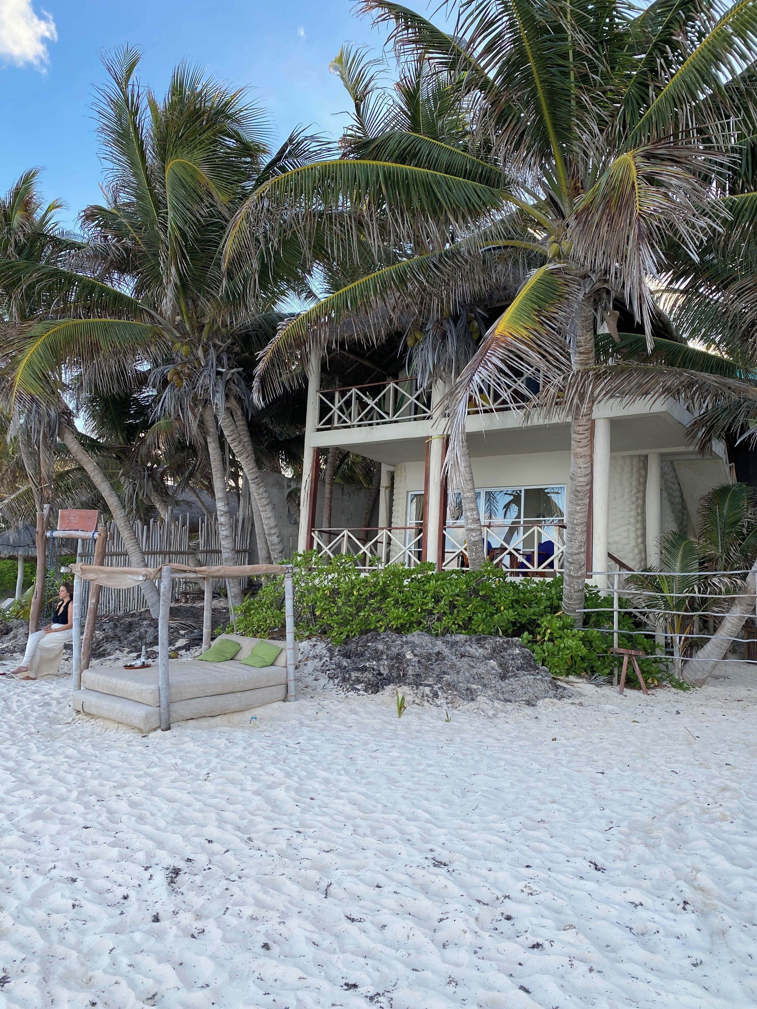 Na praia, areia branca, guarda-sóis, toalhas de praia 