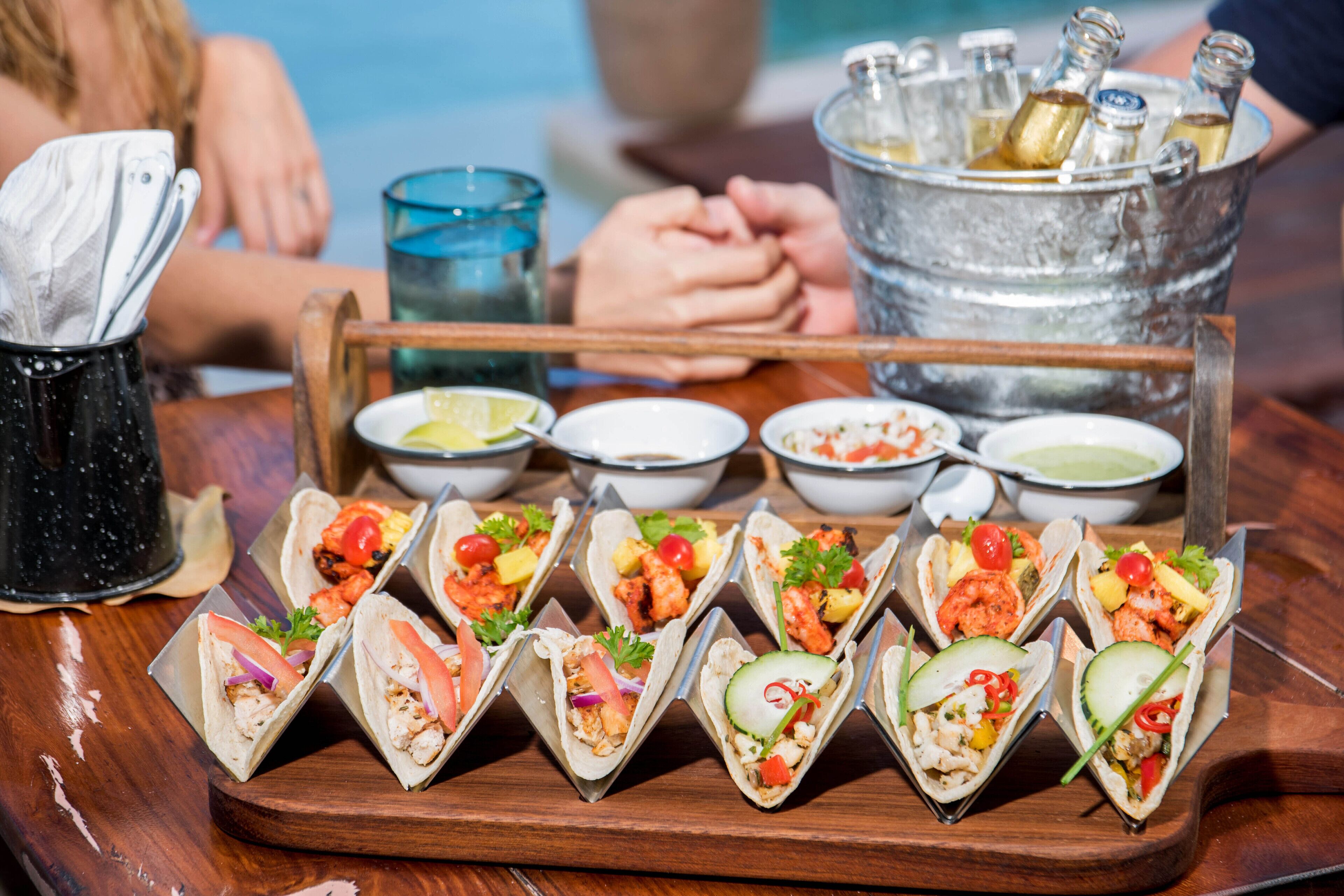 Ein Tablett mit Tacos, verschiedenen Belägen und kleinen Saucenschalen.