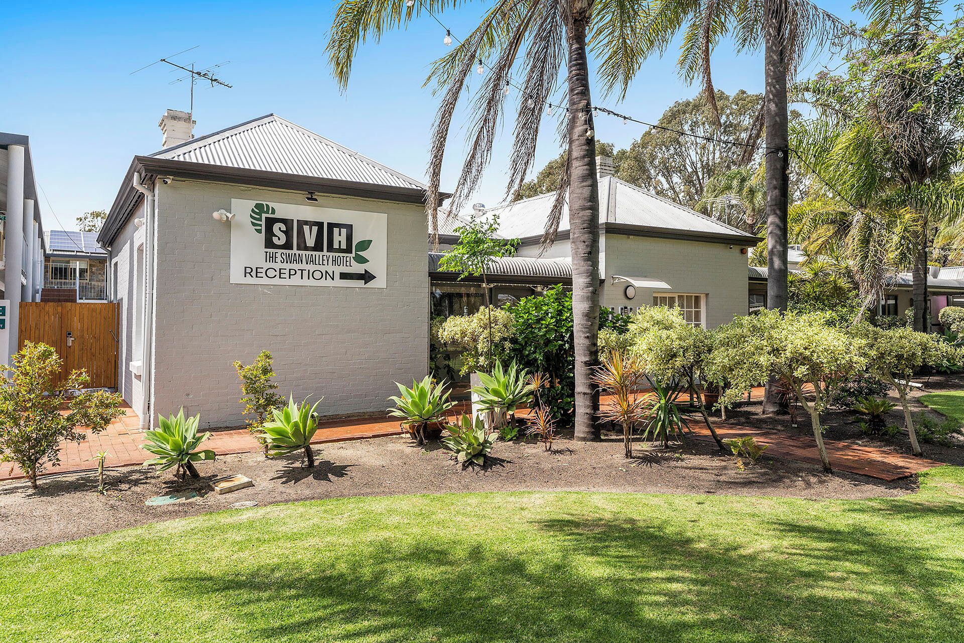 A reception area for The Swan Valley Hotel with a sign indicating the direction to the reception.