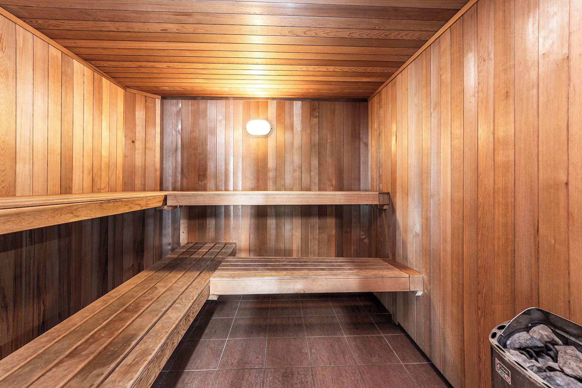 Un sauna avec des murs et des bancs en bois.