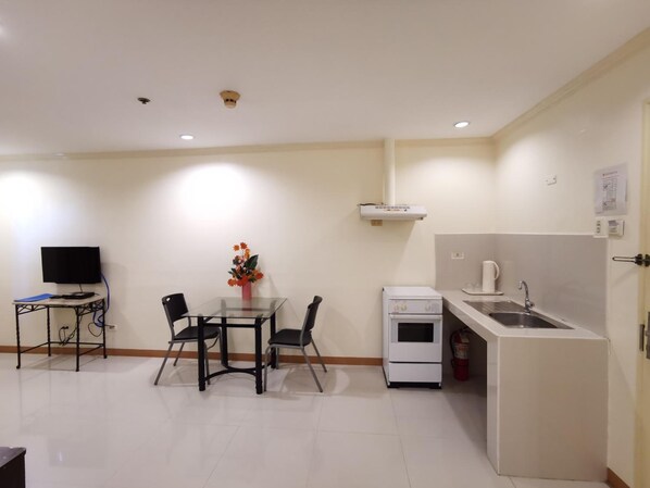 A compact kitchen with a dining area, a small oven, and a sink. - Metro Park Hotel Cebu City (Cebu City)