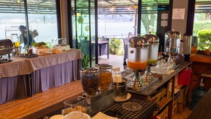A breakfast bar with various food containers and a coffee station. - Khong Chiam Orchid Riverside Resort (Khong Chiam)