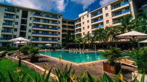 A hotel with multiple floors, a central swimming pool, and palm trees. - Sakura Residence (Yangon)