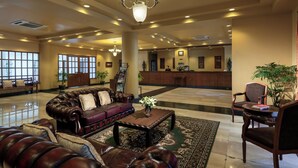 A spacious lobby with leather sofas, a wooden coffee table, and a chandelier. - Sakura Residence (Yangon)