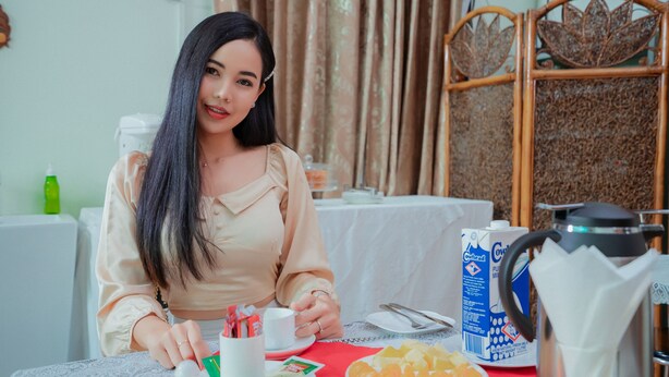 A dining table with a plate of fruit, a coffee pot, and a carton of milk. - Great Feel Hotel (Yangon)
