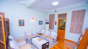A living room with a sofa set, a coffee table, and a patterned rug. - Great Feel Hotel (Yangon)