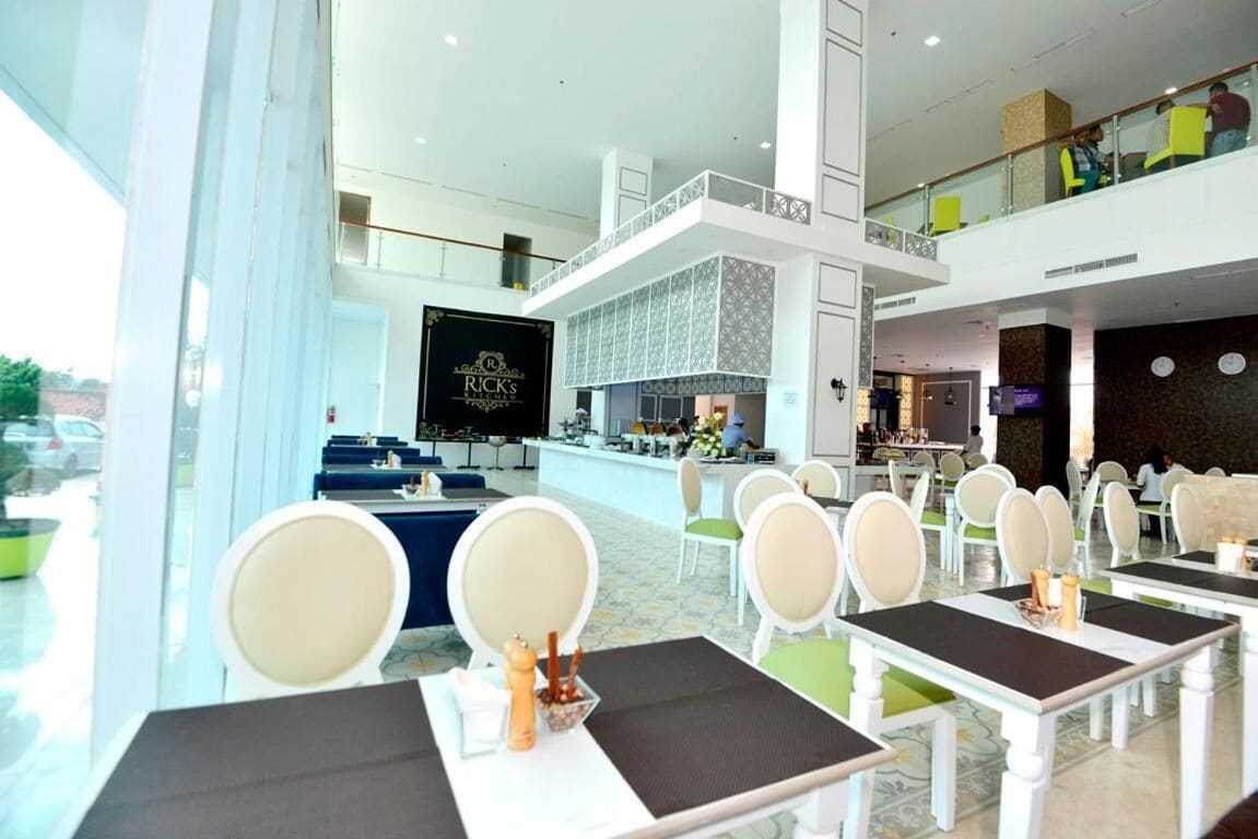 A hotel lobby with a reception desk, seating area, and a view of the street.