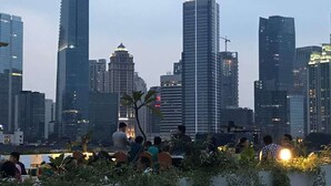 A rooftop terrace with a city skyline in the background. - Topaz Residence (Jakarta)