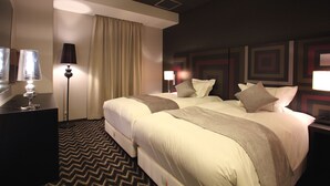 A hotel room with two beds, a desk, a lamp, and a patterned carpet. - Centurion Hotel Grand Kobe Station (Kobe)