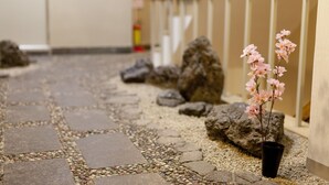 A stone pathway with a potted plant and rocks. - Shin-Okubo Sekitei Hotel (Tokyo)