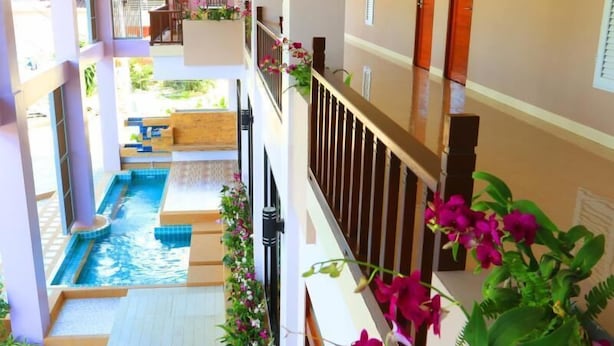 A hotel with a pool, outdoor seating, and a balcony with flowers. - Na Tubthieng Boutique Resort (Trang)