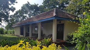 A single-story building with a tiled roof and a covered porch with chairs. - Secret Escape Nilaveli Ayurveda Hotel & Spa (Nilaveli)