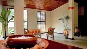 A room with a large window, a dining table with a bowl of food, and potted plants. - Secret Escape Nilaveli Ayurveda Hotel & Spa (Nilaveli)