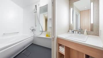 A modern bathroom with a bathtub, shower, and vanity with a mirror.