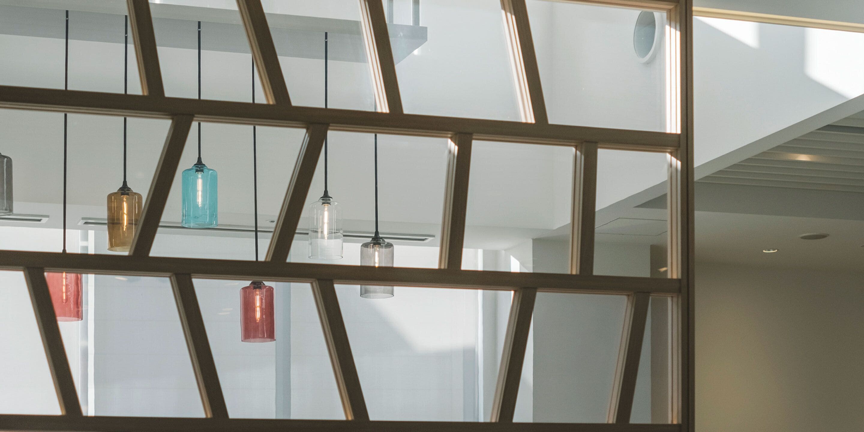 Un interior moderno con diseño geométrico en el techo e iluminación colgante.