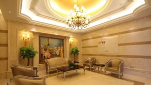 A lobby with a chandelier, seating area, and a large painting. - Shanghai Waigaoqiao Free Trade Zone Vienna Hotel (Shanghai)
