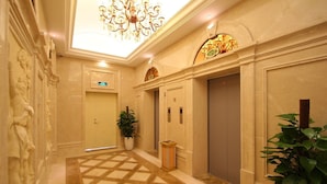 A hotel lobby with a marble floor, a chandelier, and a plant. - Shanghai Waigaoqiao Free Trade Zone Vienna Hotel (Shanghai)