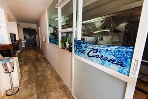 Un pasillo con una cocina visible a través de un separador de vidrio.