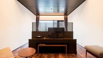 A modern living room with a flat-screen TV, a coffee table, and a bench.