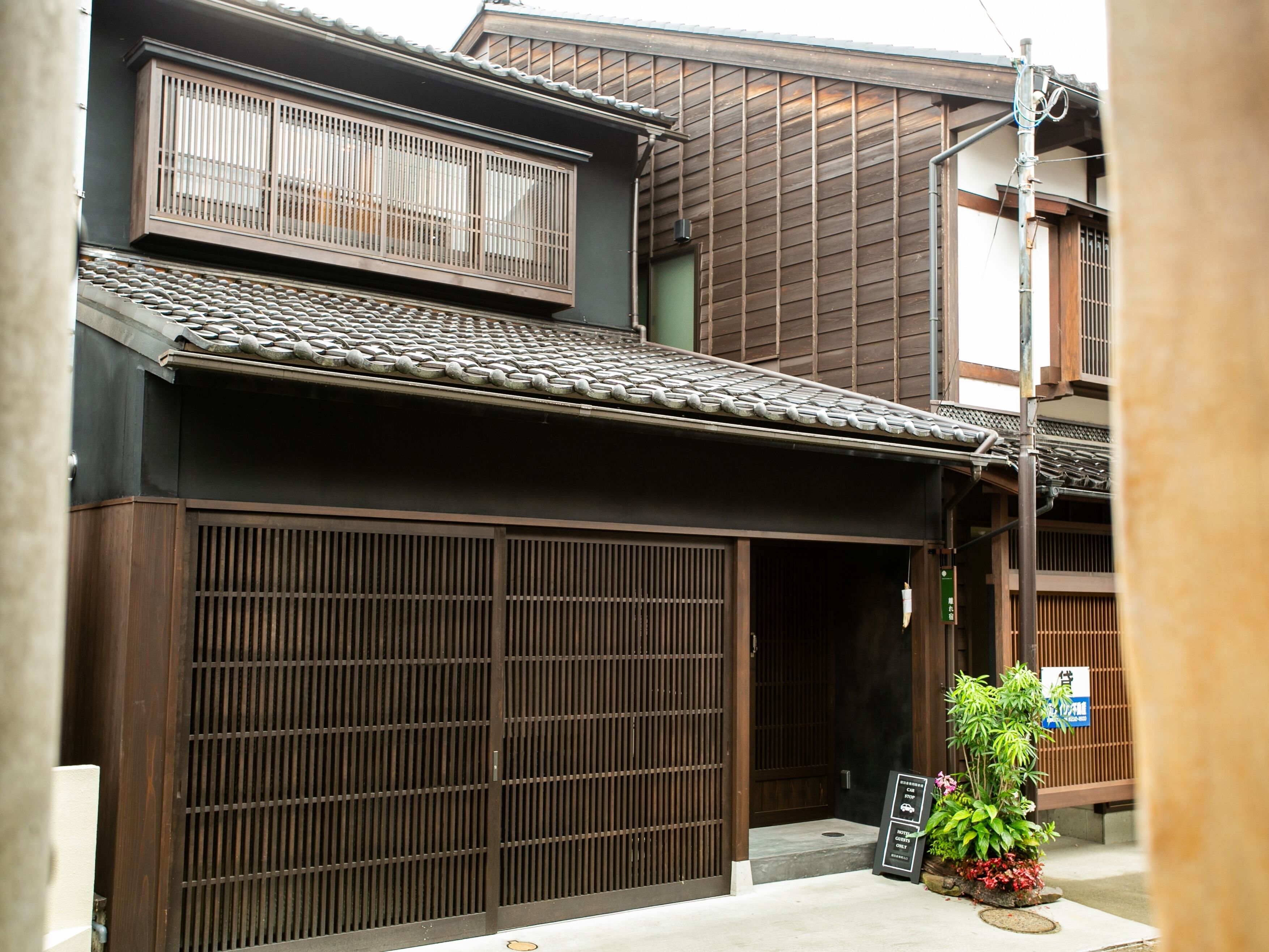 Un edificio japonés tradicional con fachada de madera, tejado de tejas y puerta corredera.