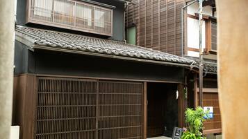 Un edificio japonés tradicional con fachada de madera, tejado de tejas y puerta corredera.