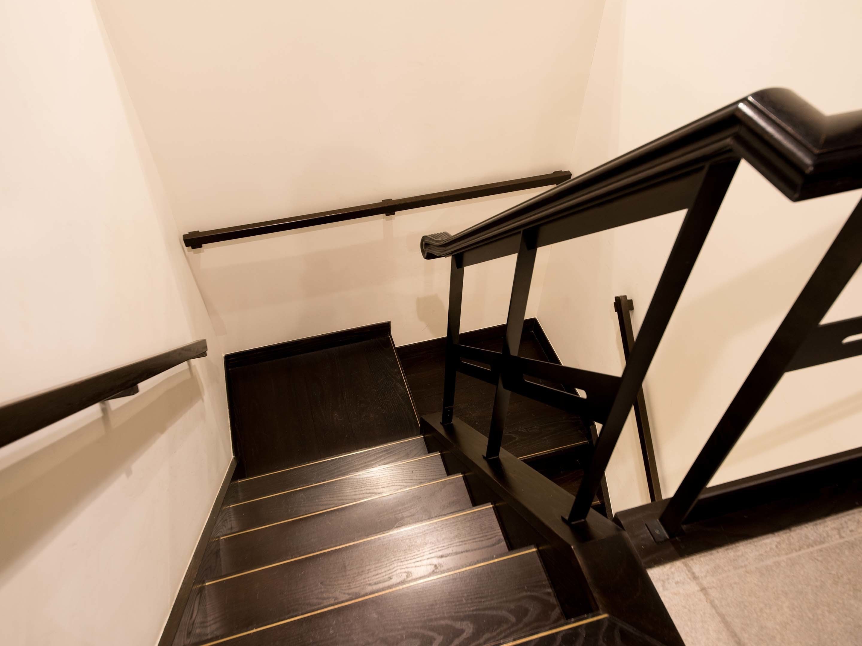 A staircase with black handrails and wooden steps.