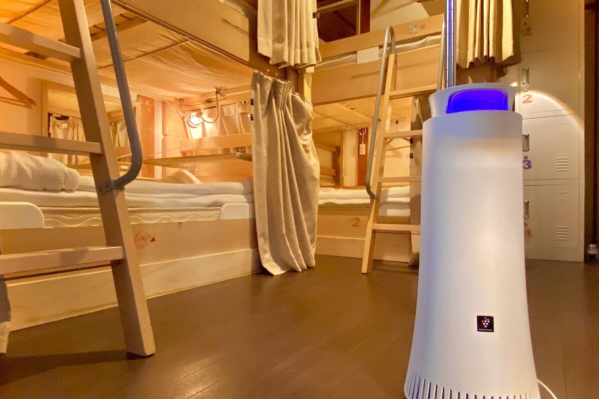 Une chambre avec un lit superposé, un radiateur et une valise.